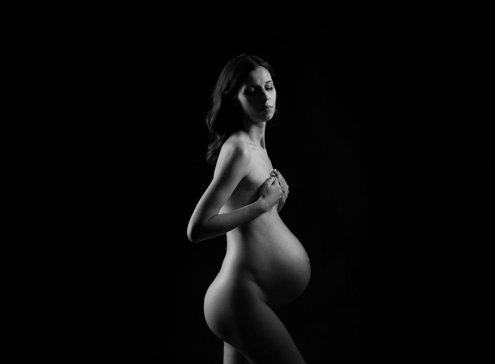 Black and white artistic nude photography series showing silhouetted pregnant figure in different graceful poses.