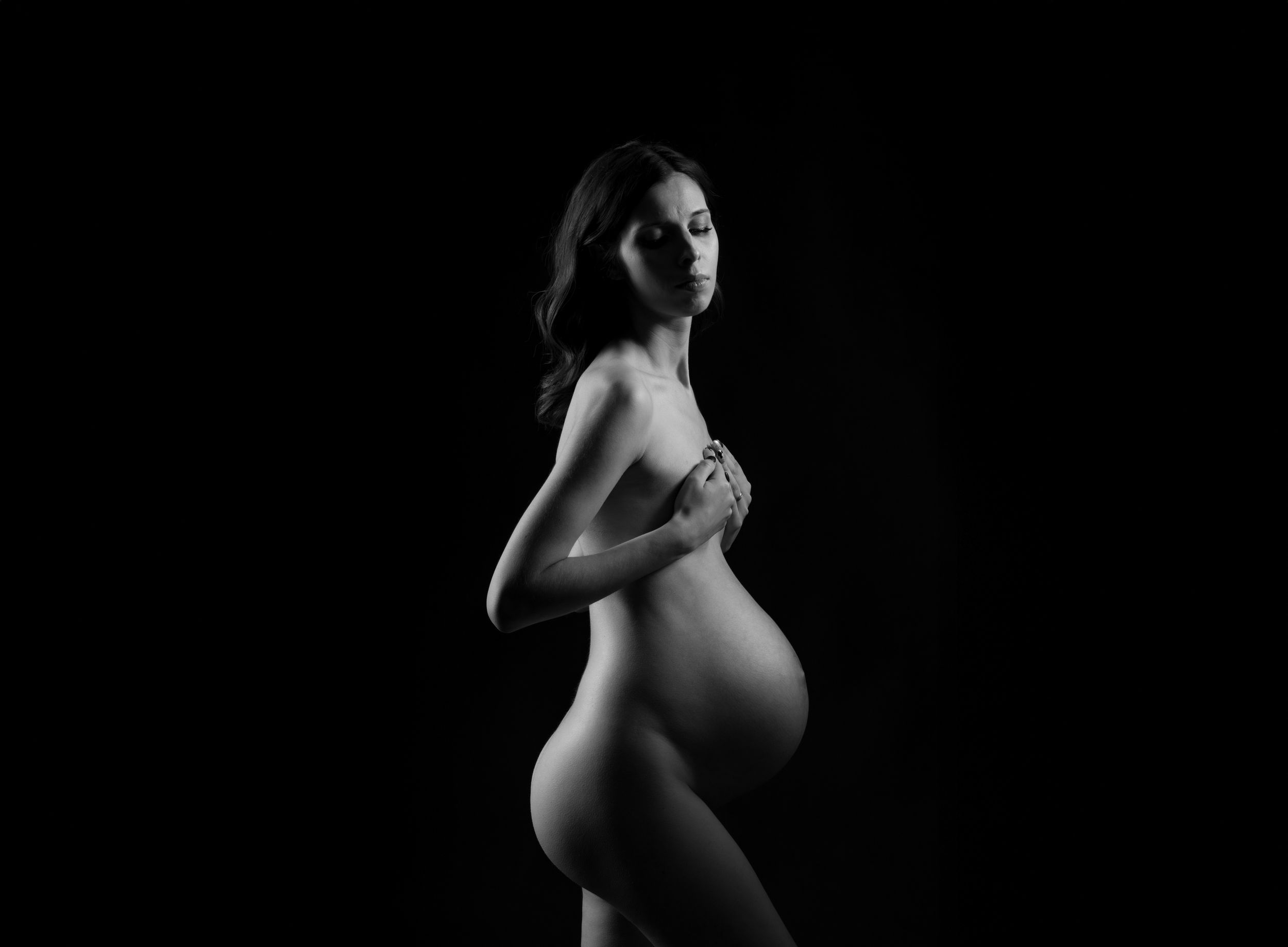 Black and white artistic nude photography series showing silhouetted pregnant figure in different graceful poses.