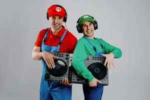 Two people dressed as video game characters Mario and Luigi pose together in a playful stance.