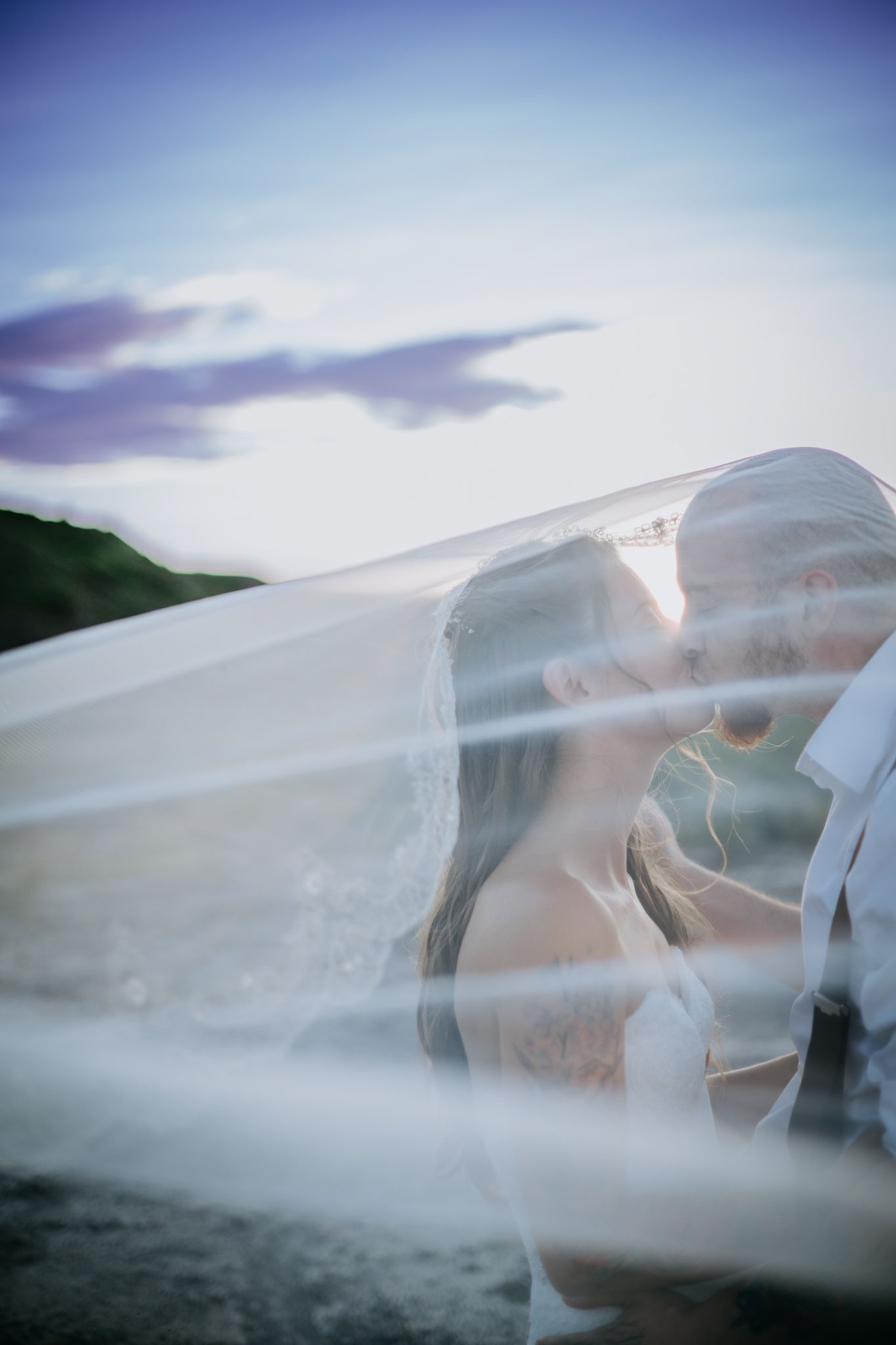 Ethereal artistic photos showing figures draped in flowing white fabric against a misty sky background.