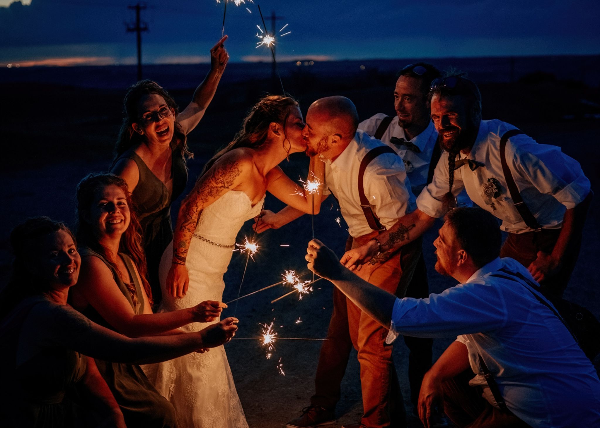 A series of nighttime sparkler photos showing people celebrating and creating light trails in the darkness.