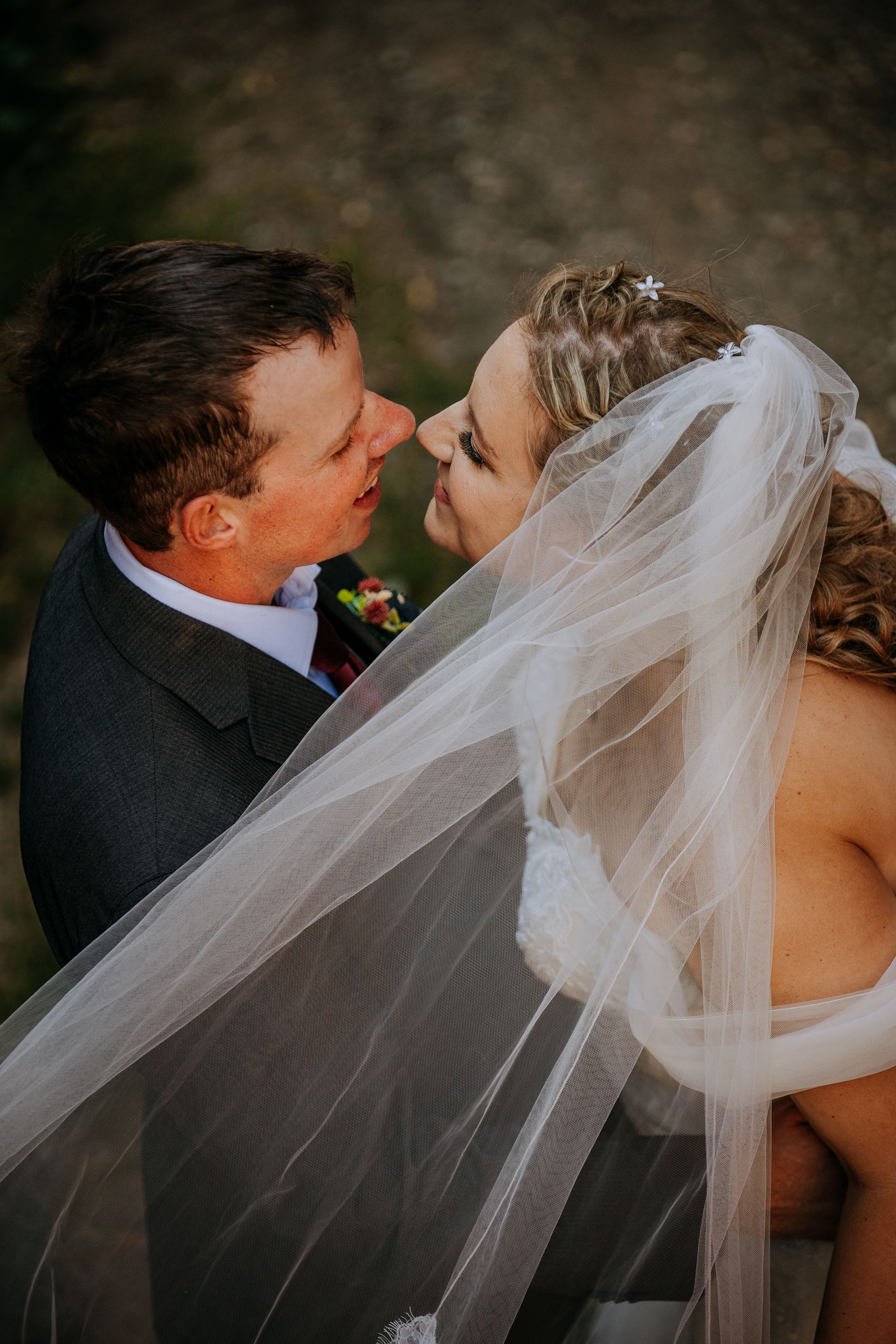 A romantic sequence of wedding photos showing a couple sharing a tender kiss while the bride's white veil flows in the breeze.