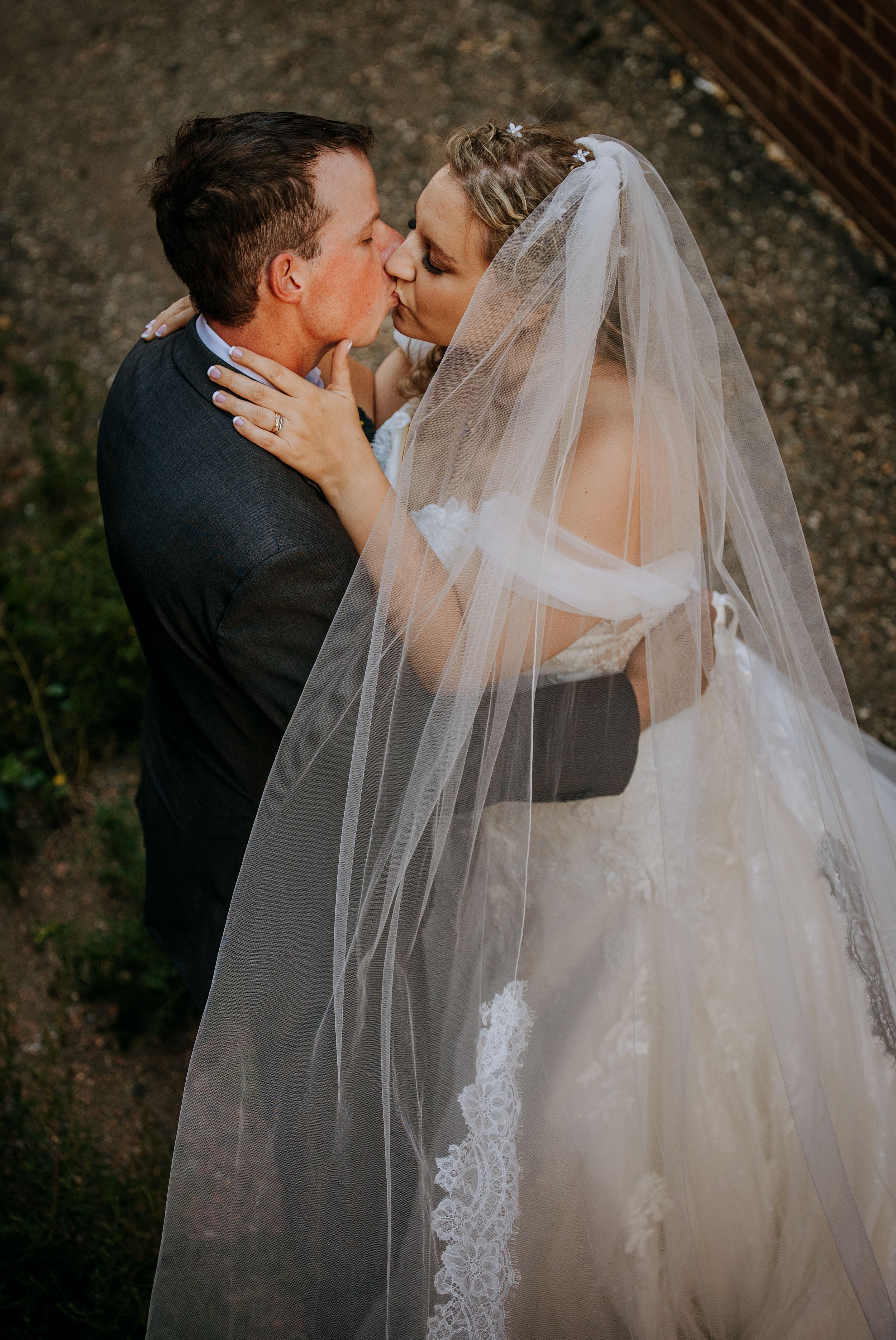 A romantic sequence of wedding photos showing a couple sharing intimate kisses under a flowing white veil.