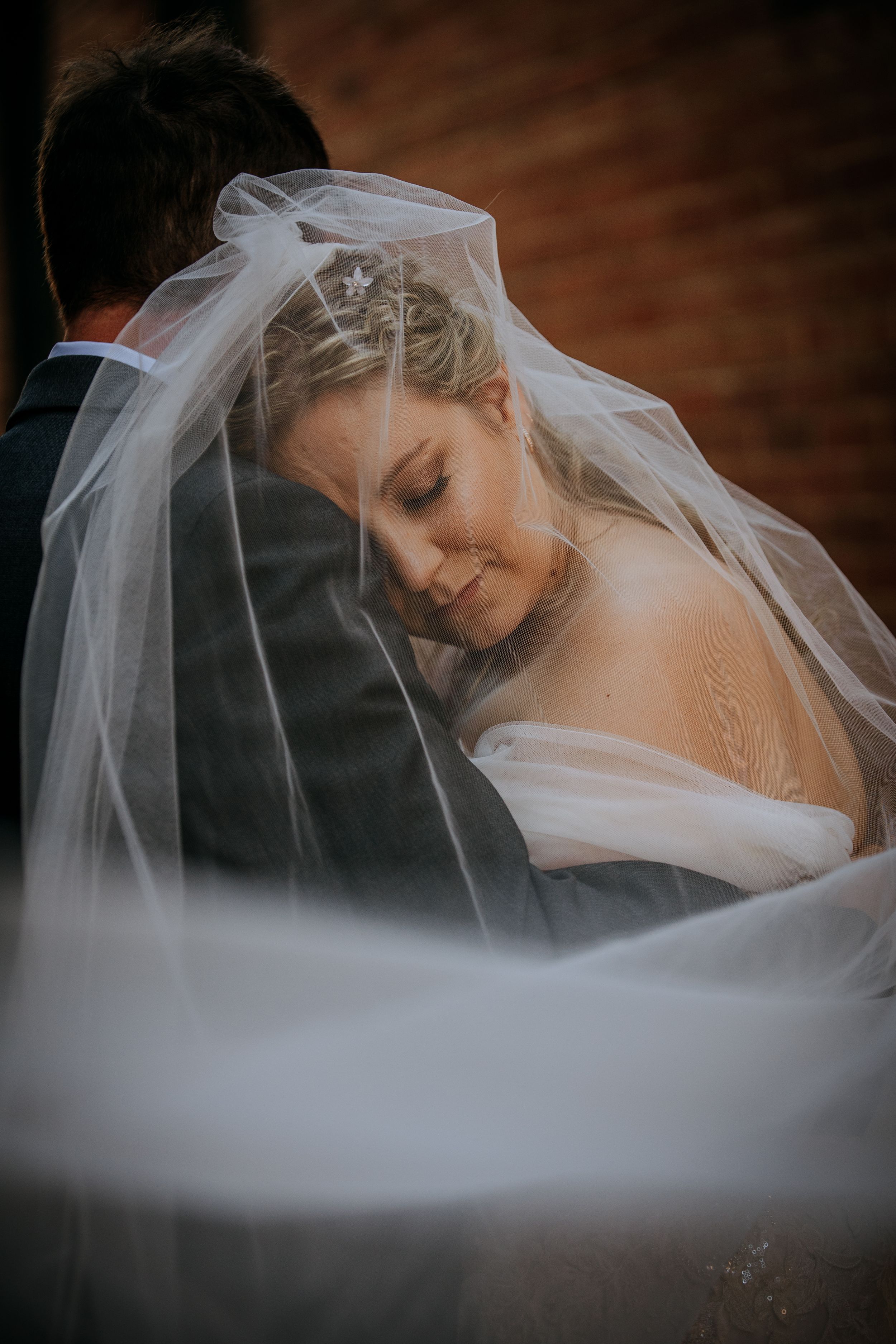 A bride wearing a flowing white veil is captured in a series of romantic close-up shots against a dark background.