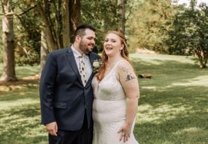 A couple shares a joyful laugh during their outdoor wedding portraits.
