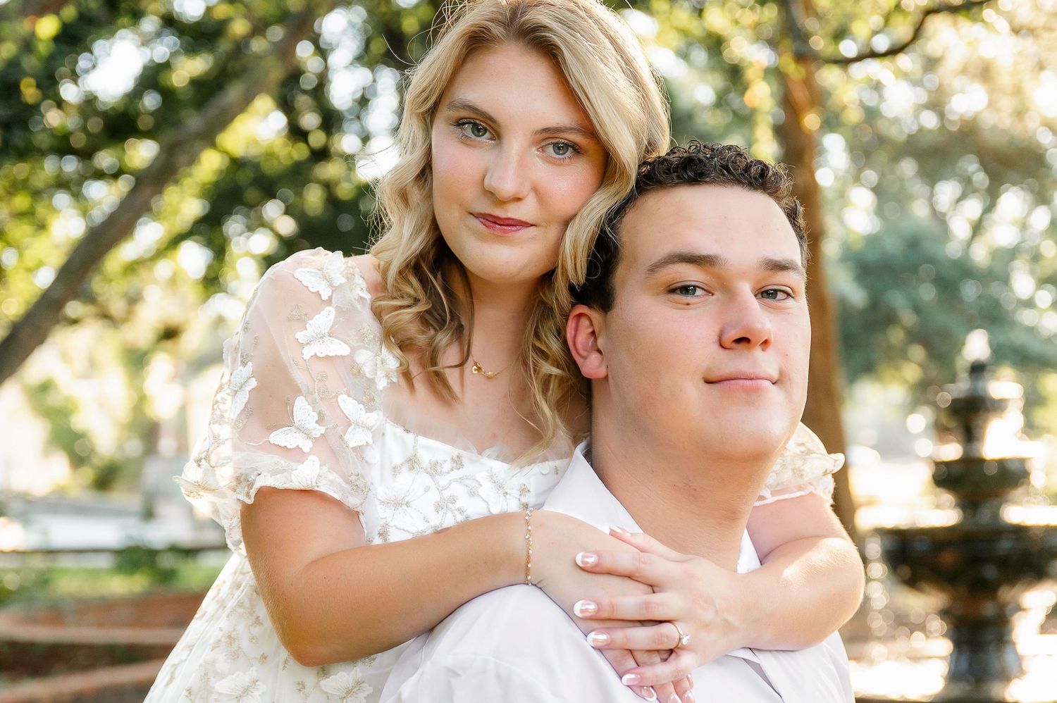 A romantic couple's portrait session in a sun-dappled garden setting.