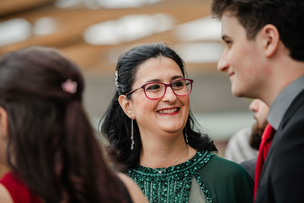 A group of business professionals smile and engage in conversation at a networking event.