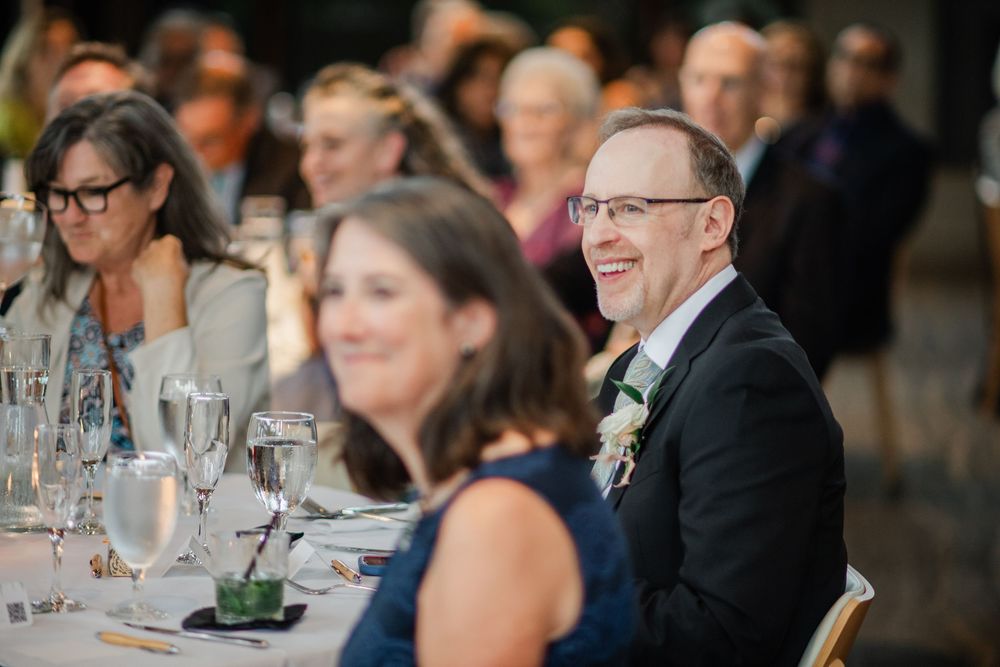 Wedding reception guests seated at long tables during dinner service.