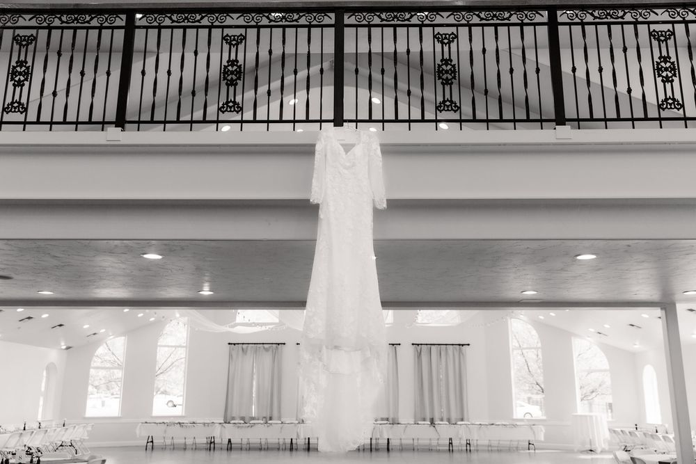 A panoramic black and white interior view of an empty church sanctuary with rows of pews and arched windows.