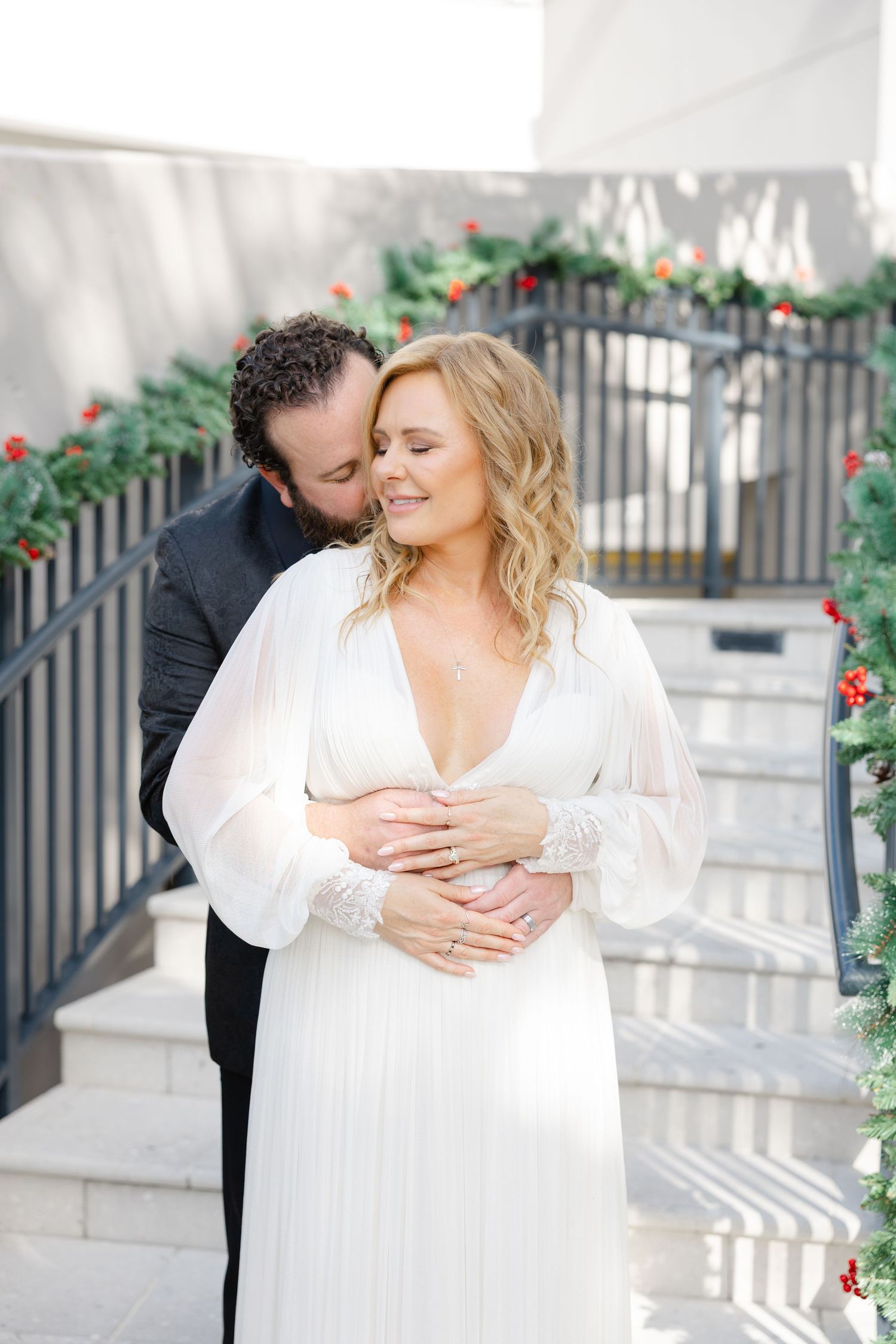 Bride and groom holding each other during an outdoor wedding portrait.