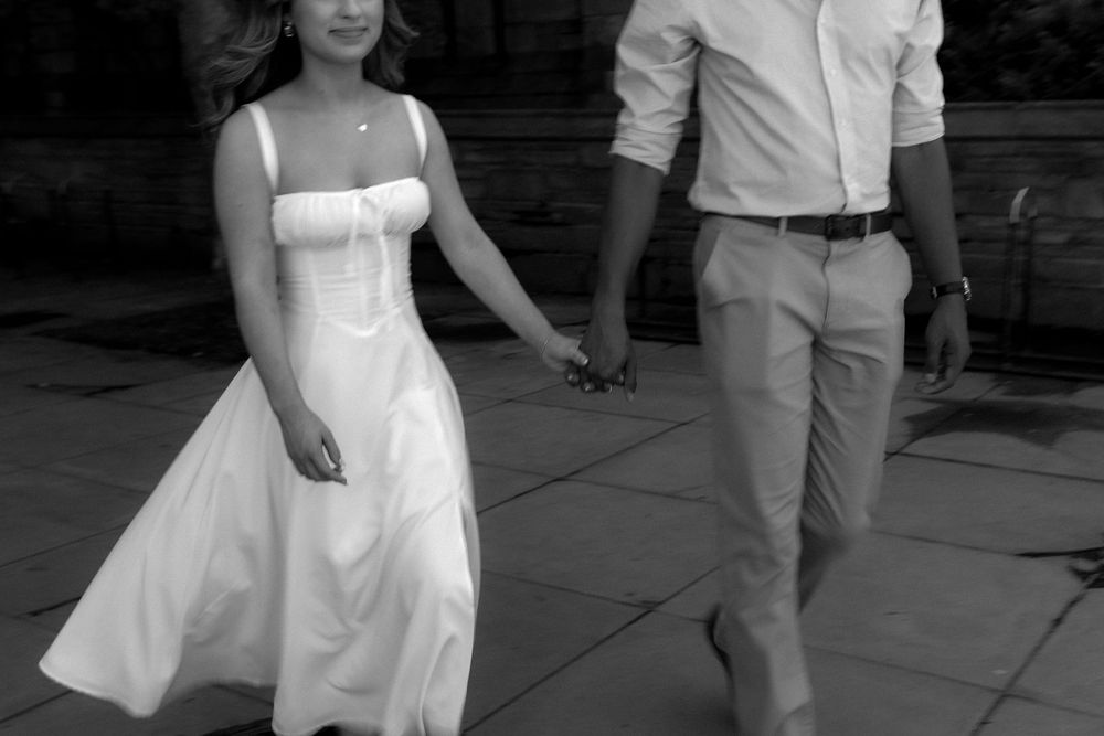 A couple in light summer attire dances together on an outdoor terrace.