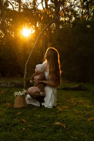 Sunset illuminates a peaceful outdoor moment on grass with warm golden light filtering through trees.