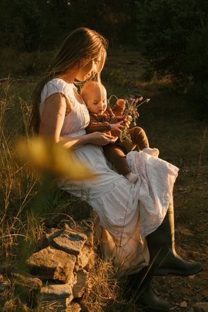 Warm sunset light illuminates a peaceful outdoor scene with white clothing against natural textures.