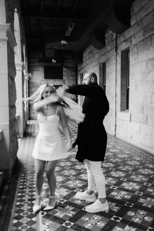 Black and white series of dance poses showing graceful movement and spinning in an ornate hallway.