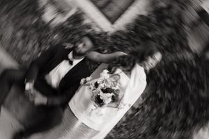 Aerial black and white photo of bride and groom with bouquet spinning.