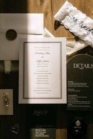 Classic wedding invitation suite for Courtney and Kyle displayed with garter and wedding details card.