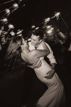 Bride and groom share romantic dance surrounded by sparkling sparklers at wedding reception.