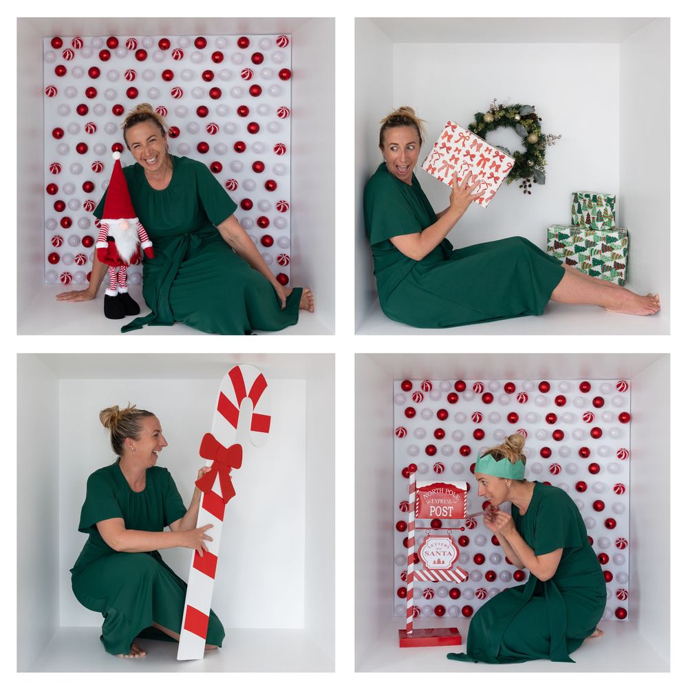 Person in green scrubs poses playfully against white wall with red polka dot backdrop and festive candy cane decorations.