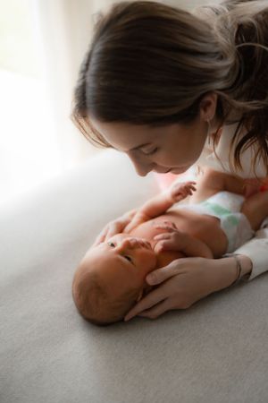 Intimate moment between parent and baby in soft natural window light.