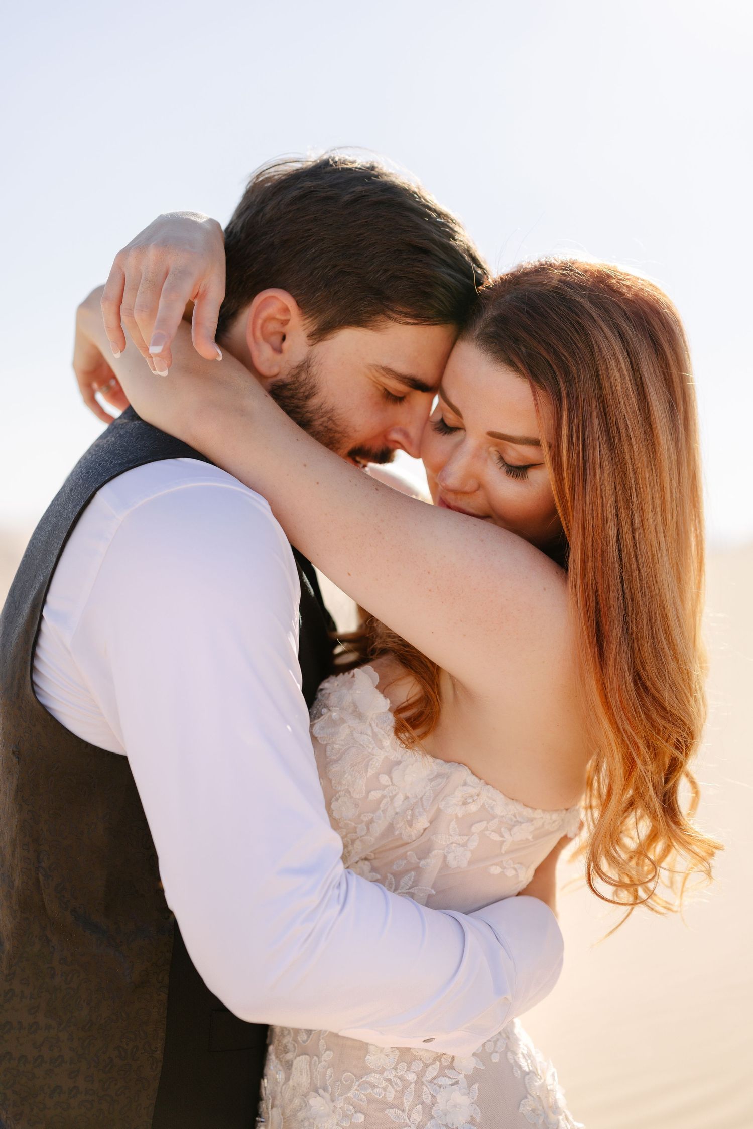 A couple sharing a tender embrace during desert wedding photo session.