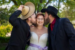 bride with brothers kissing her cheeks