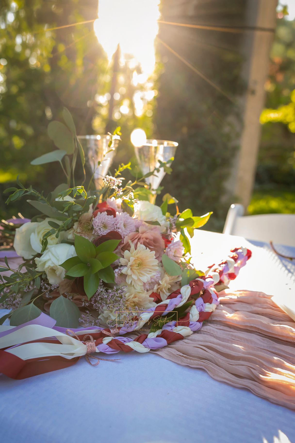 bouquet and handfasting tie on table with sun light coming through