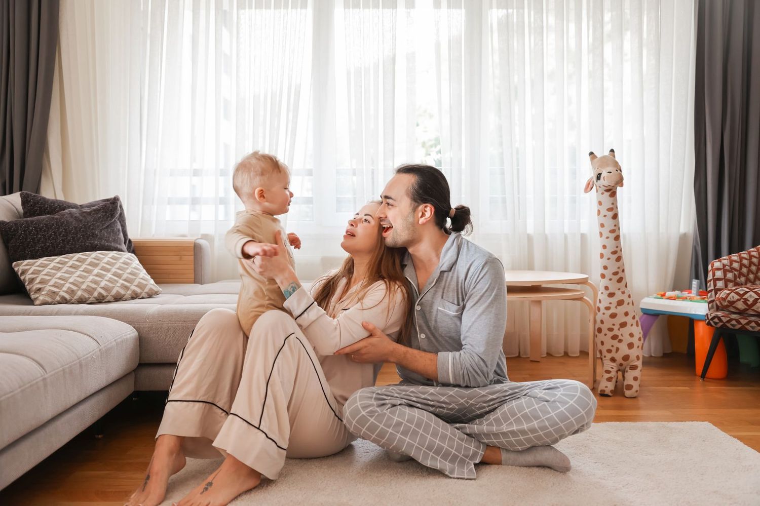 Intimate family moment in a modern living room with decorative giraffe toy in background.