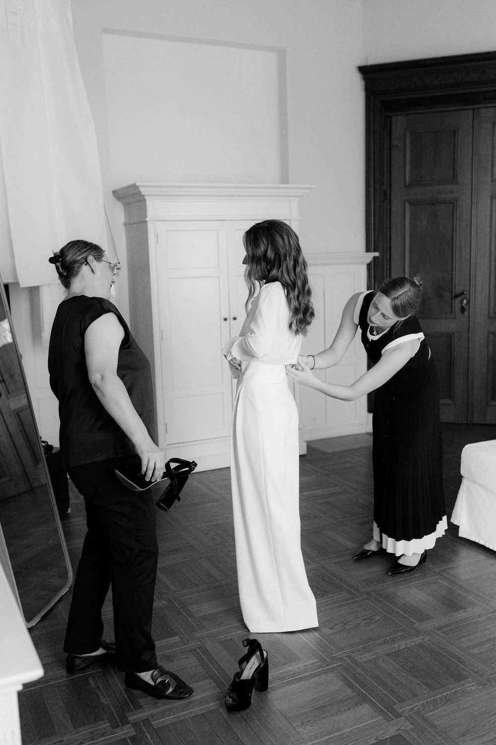 A sequence of black and white photos showing a couple dancing together in a formal room with dark doorways.