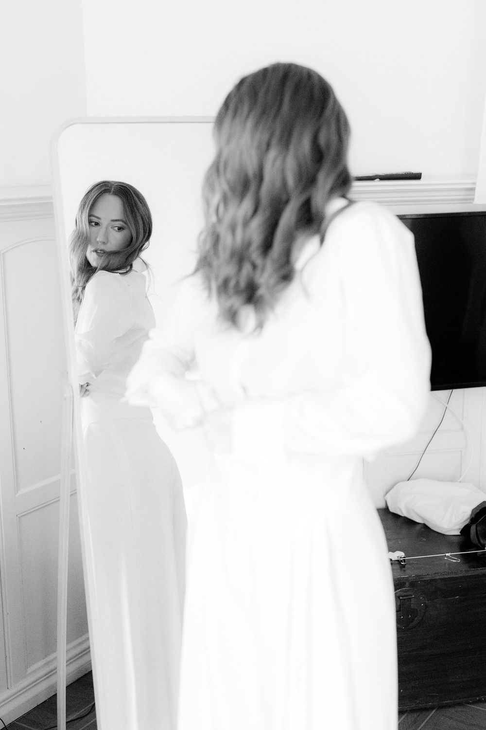 A series of blurred motion photographs showing a person in white moving through a bright interior space.