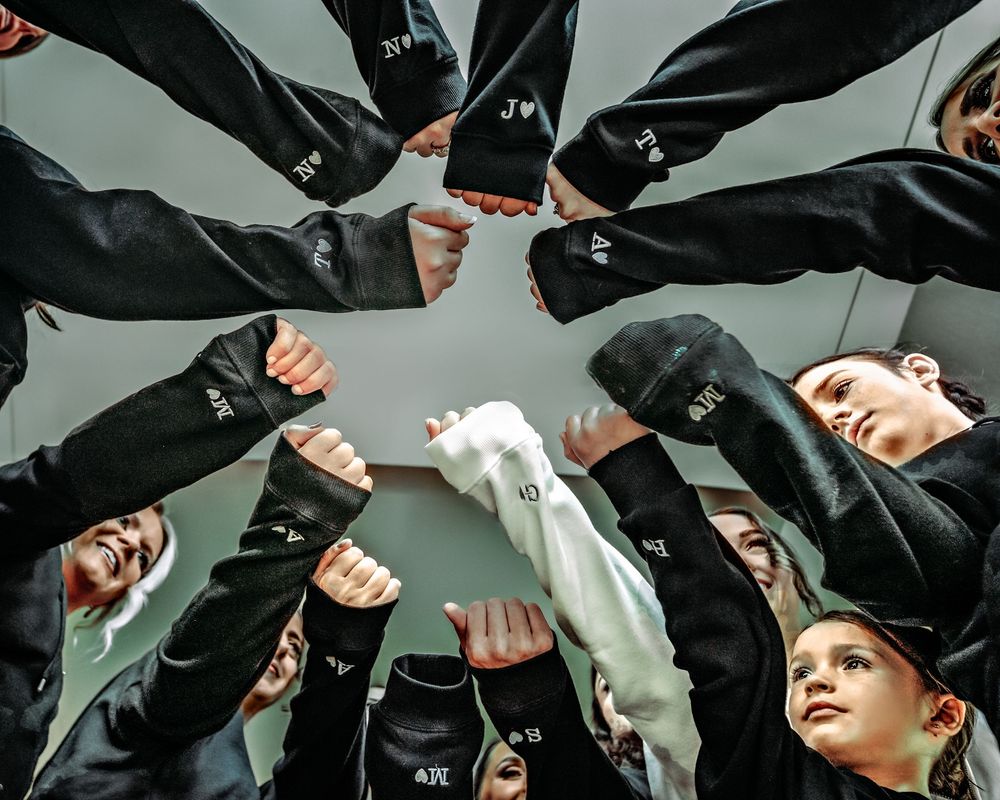 Graduates in black caps and gowns throw their mortarboards into the air during a graduation ceremony celebration.