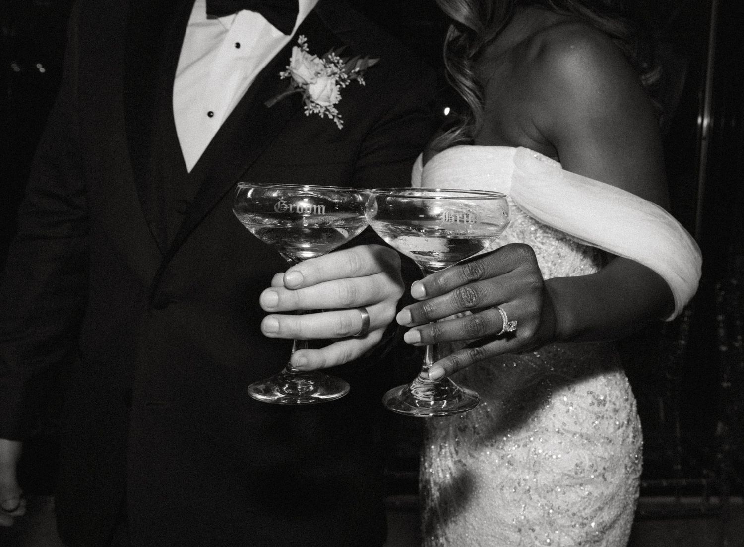 Wedding reception guests toasting with champagne glasses in black and white.