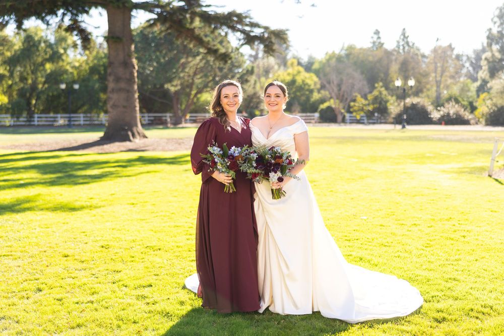 Two people in formal attire share a romantic moment in a sunlit field during golden hour.