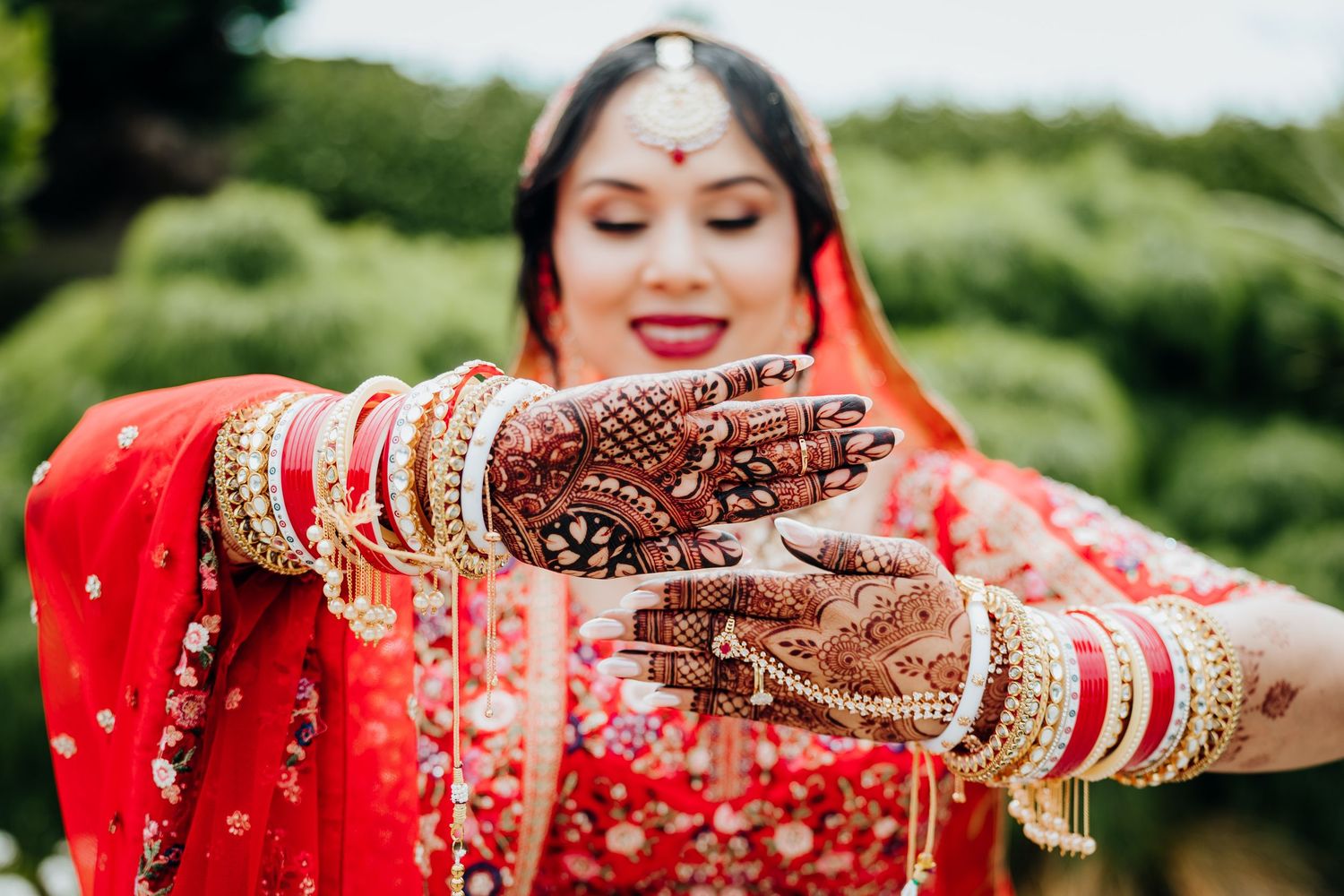 Wedding guests toss colorful confetti in celebration during an outdoor ceremony.