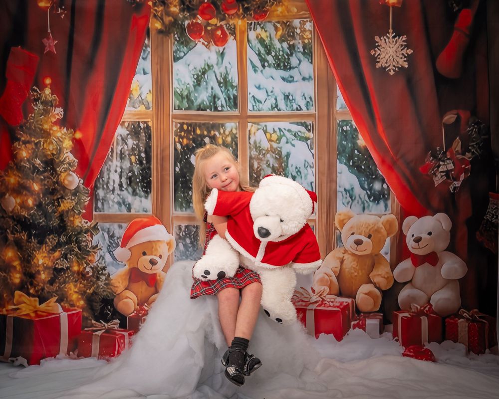 Festive holiday scene with teddy bears, Christmas decorations, and presents by a snowy window with red curtains.