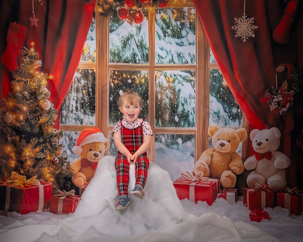A cozy Christmas scene with teddy bears, presents, and decorations by a window with snowy winter views outside.