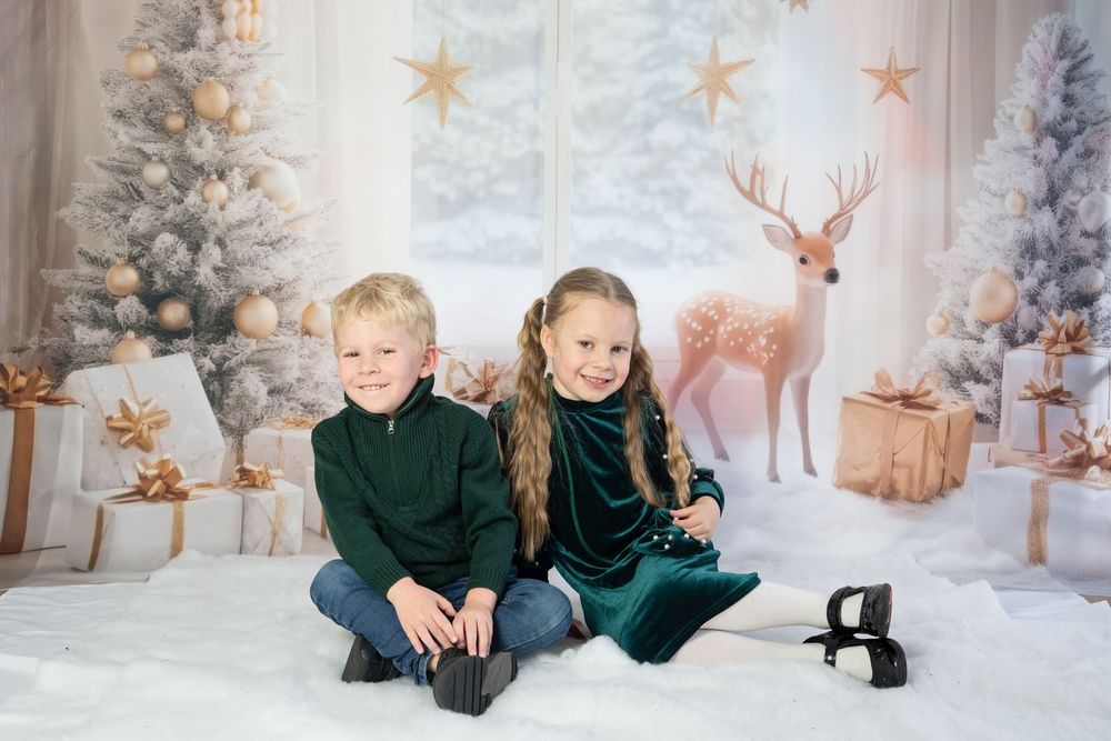 Children play and laugh together in a magical winter wonderland setting with snow-covered trees and twinkling lights.