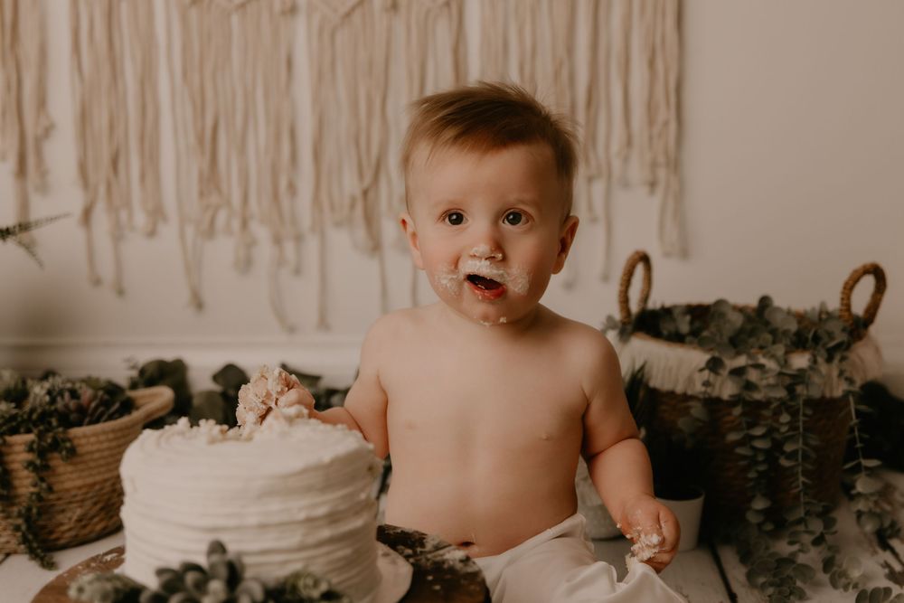 A collection of cake smash photos showing a baby enjoying their first birthday cake against a neutral backdrop.