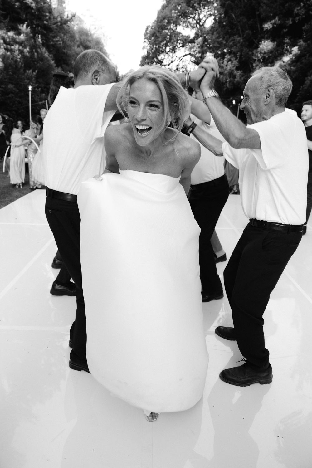 Black and white photo sequence of joyful dancing at a wedding celebration.