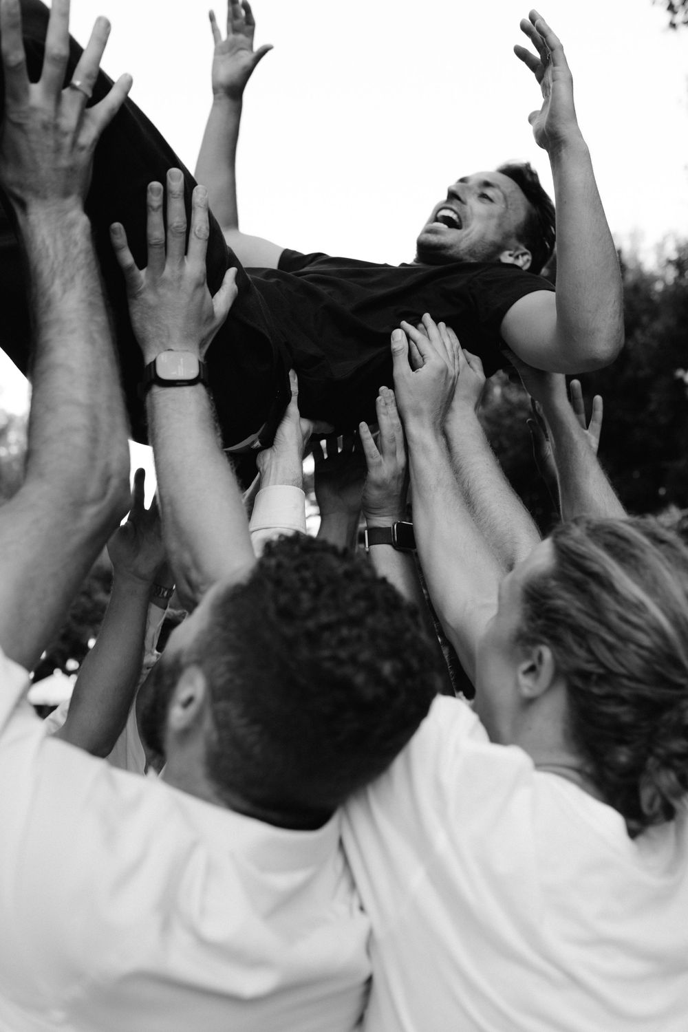 Black and white photo showing raised hands of an enthusiastic crowd at an event.