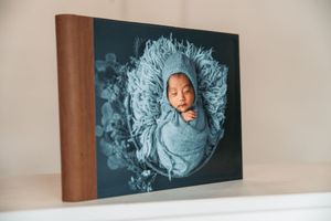 Professional photography prints displayed on a wall showcase artistic portraits in blue tones.