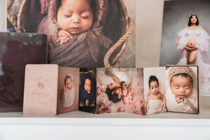Photography studio wall display featuring multiple portrait prints and artwork.