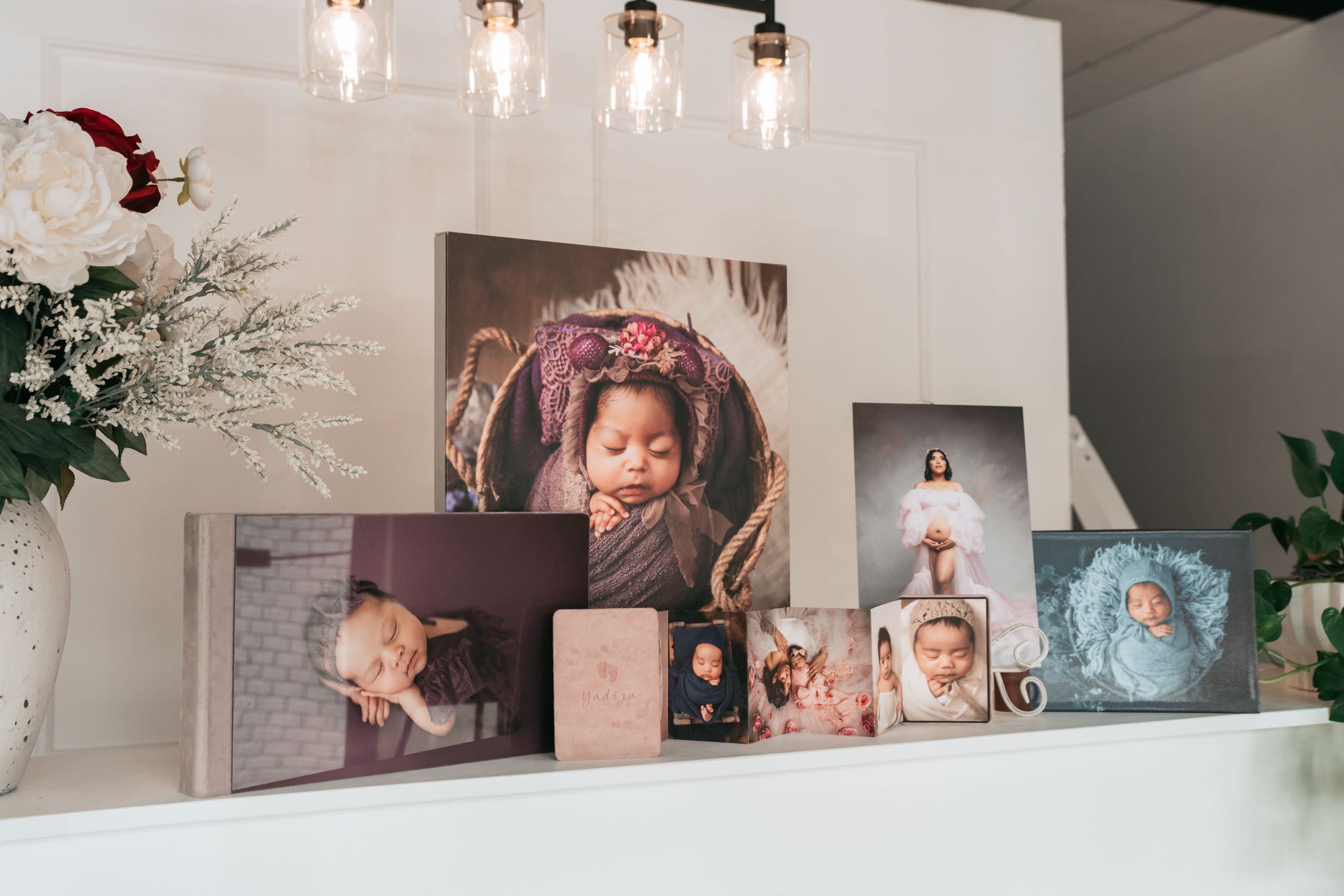 Modern photography studio interior with gallery wall and pendant lighting fixtures.