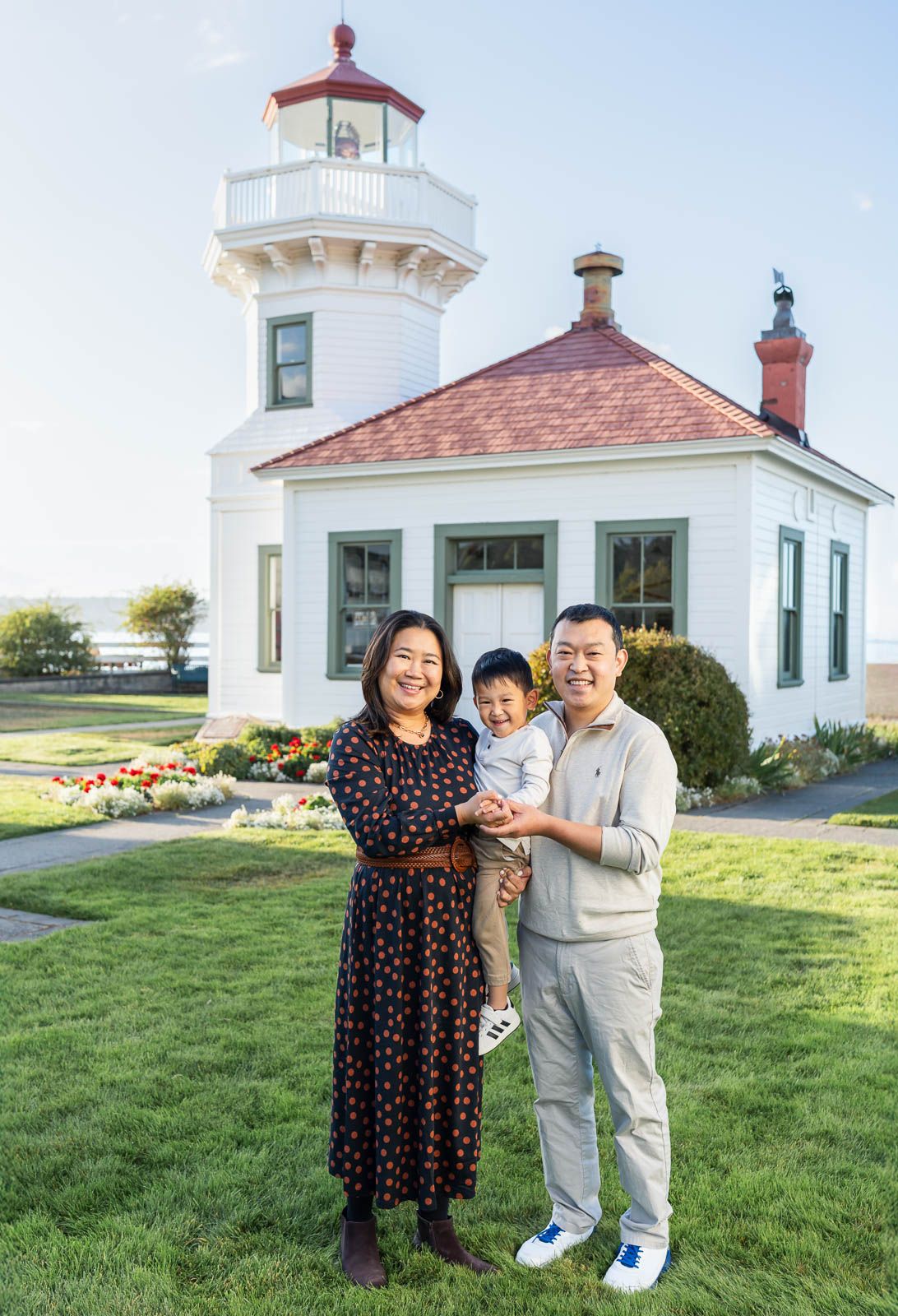 Family poses for photo by the Mukilteo lighthouse.