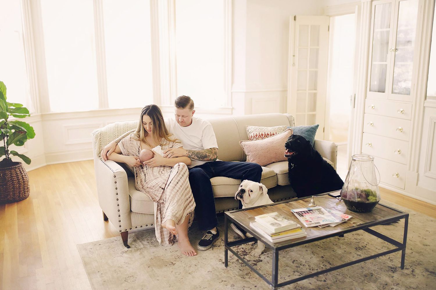Family relaxing together on couch in bright modern living room.