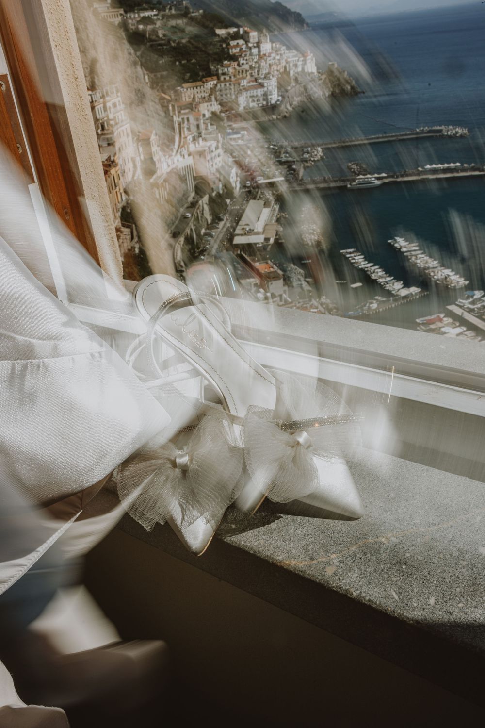 White bow detail with coastal landscape and marina view through window.
