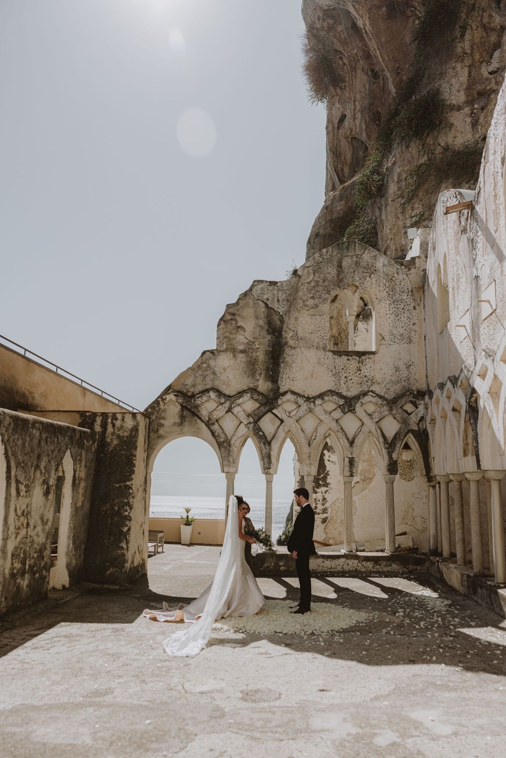 Ancient stone cloister with arched columns and dramatic lighting.