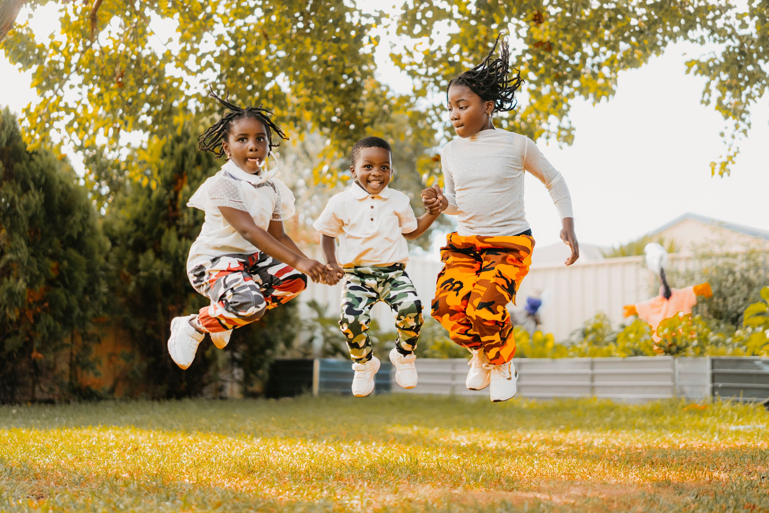 A family plays together in a golden autumn field during sunset, creating joyful moments in nature.