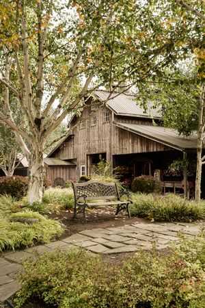 Rustic wooden barn buildings nestled among autumn trees on a rural property.
