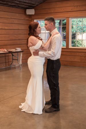 Couple dancing together in an elegant wooden lodge room with polished concrete floors.