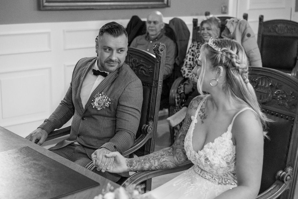 A series of black and white wedding photos showing candid moments and laughter during a celebration.